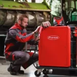 Зварювальник налаштовує апарат Fronius Fortis у промисловій майстерні